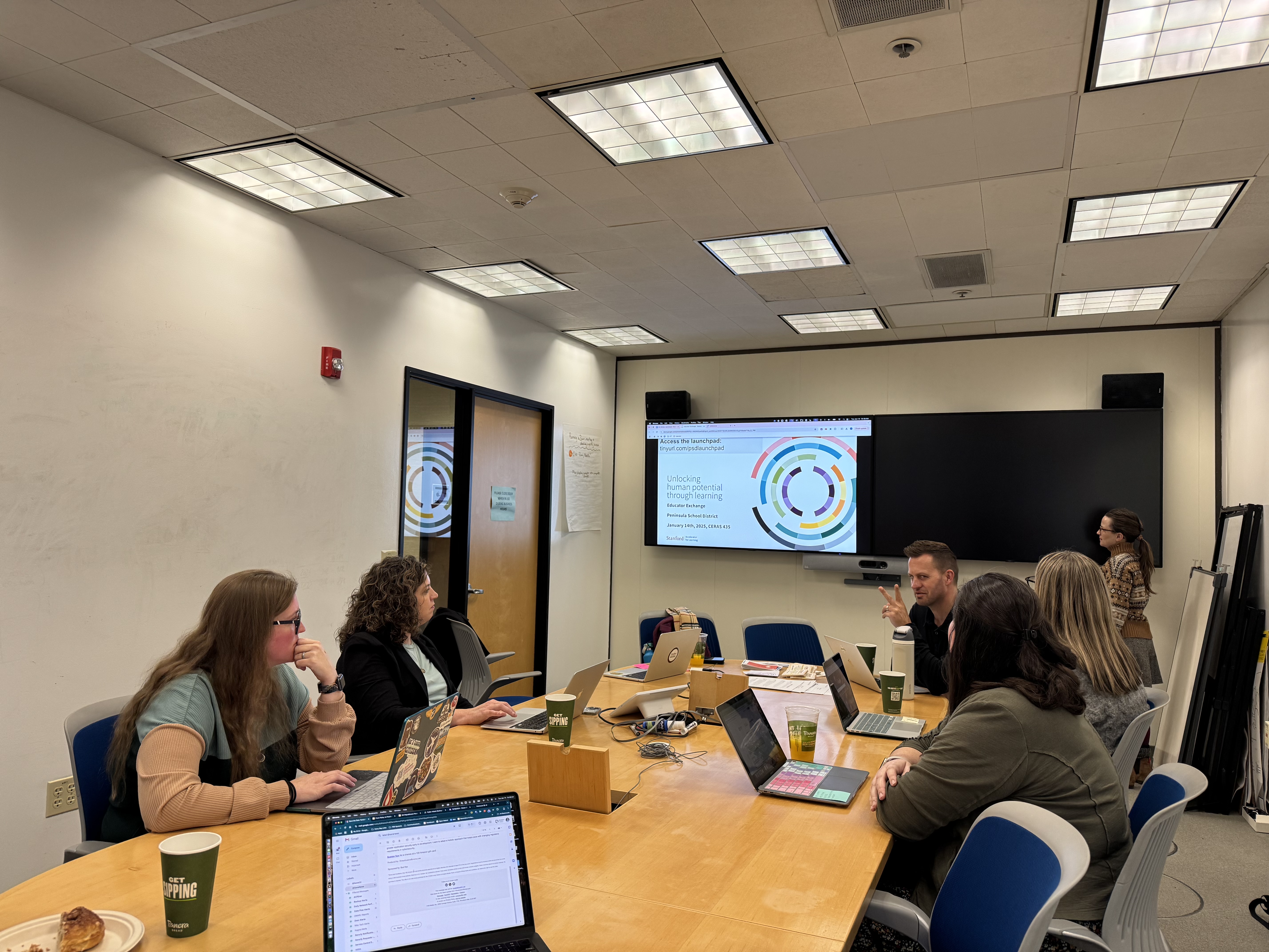 five educators and one stanford staff member working collaboratively in a conference room on building out AI resources
